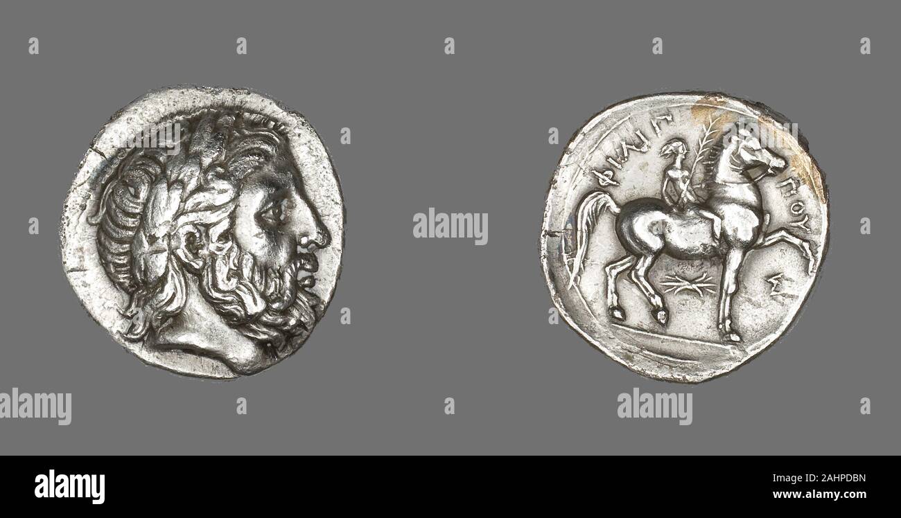 Ancient Greek. Tetradrachm (Coin) Depicting the God Zeus. 348 BC–336 BC. Pella. Silver The purpose of the first portrait coins was to identify the ruler. The front side became a mirror of the sovereign’s self-image. The back was often used to communicate the ruler’s accomplishments or intentions. The profile portrait was used because it suited the very shallow depth and limited surface of the coin. The tiny images were carved by engravers into bronze dies, one for the front and another for the back. The coins were then struck, one by one, in a process similar to how modern coins are created to Stock Photo