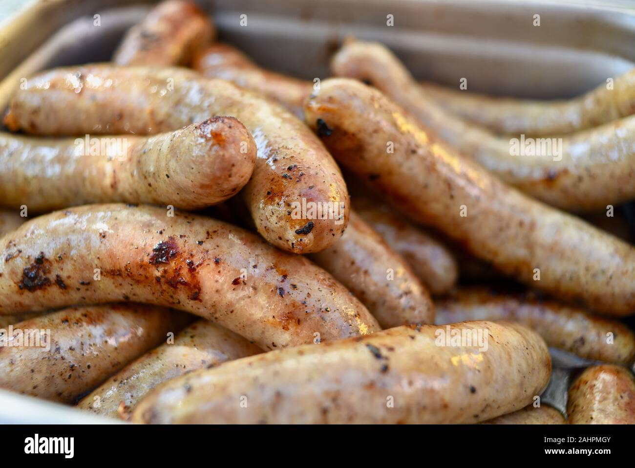 Grilled bratwurst sausages piled up in a serving tray for sale at Oktoberfest held in the Swiss-American community of New Glarus, Wisconsin, USA. Stock Photo