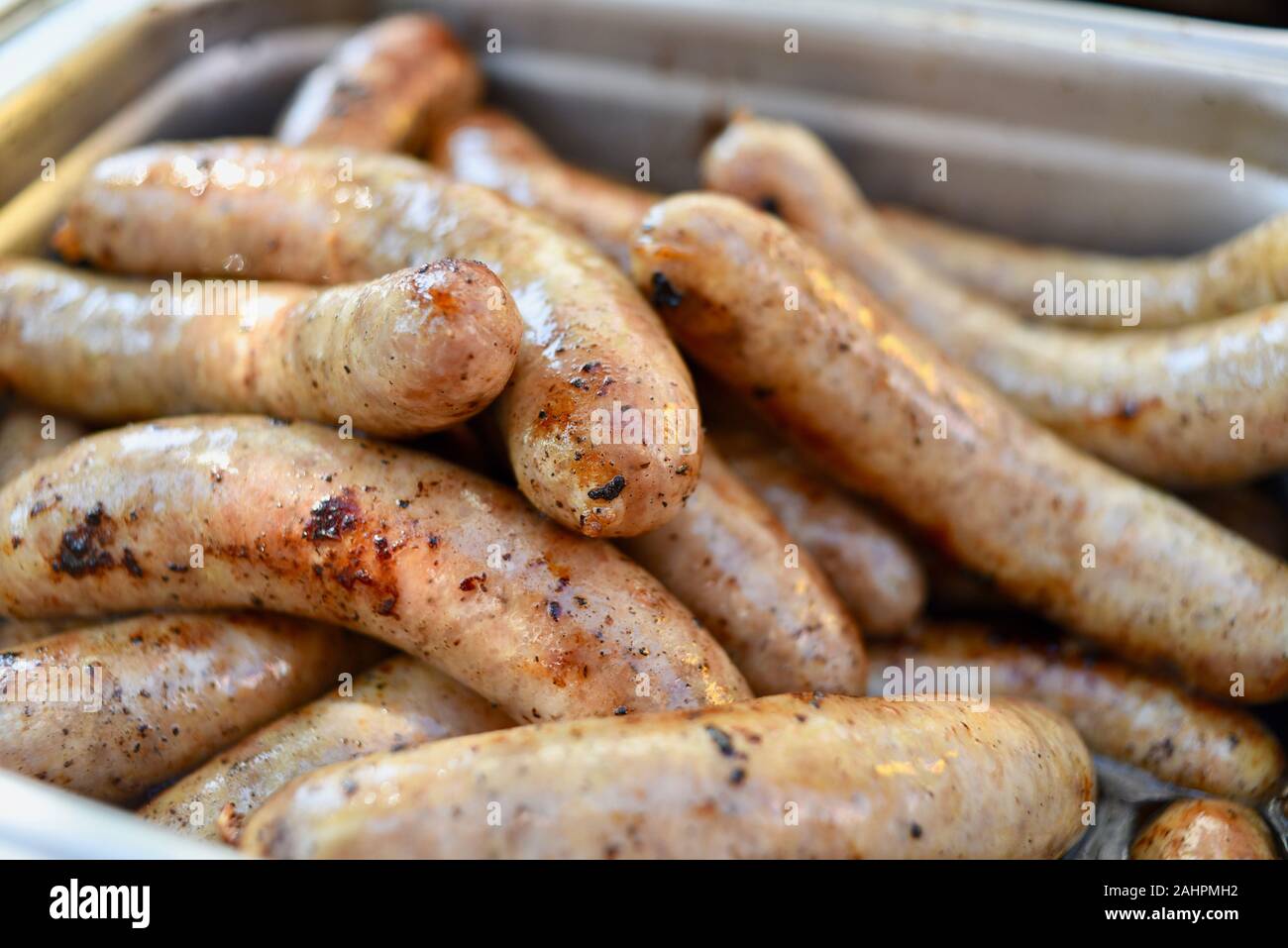 Grilled bratwurst sausages piled up in a serving tray for sale at Oktoberfest held in the Swiss-American community of New Glarus, Wisconsin, USA. Stock Photo