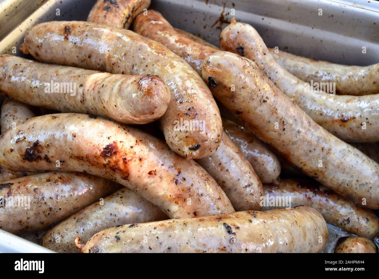 Grilled bratwurst sausages piled up in a serving tray for sale at Oktoberfest held in the Swiss-American community of New Glarus, Wisconsin, USA. Stock Photo