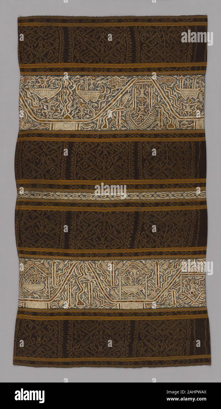 Paminggir. Woman's Ceremonial Skirt (tapis). 1801–1900. Sumatra. Six panels joined four panels of stripes of cotton, warp resist dyed (warp ikat), plain weave with paired warps and stripes of cotton and silk warp-faced, weft ribbed plain weave with supplementary brocading wefts and a stripe of cotton, plain weave; embroidered with silk in double running, stem and surface satin stitches and two panels of cotton, plain weave; embroidered with silk in chain, double running, split, and surface satin stitches; mirror pieces; gilt-metal pieces attached with silk Stock Photo