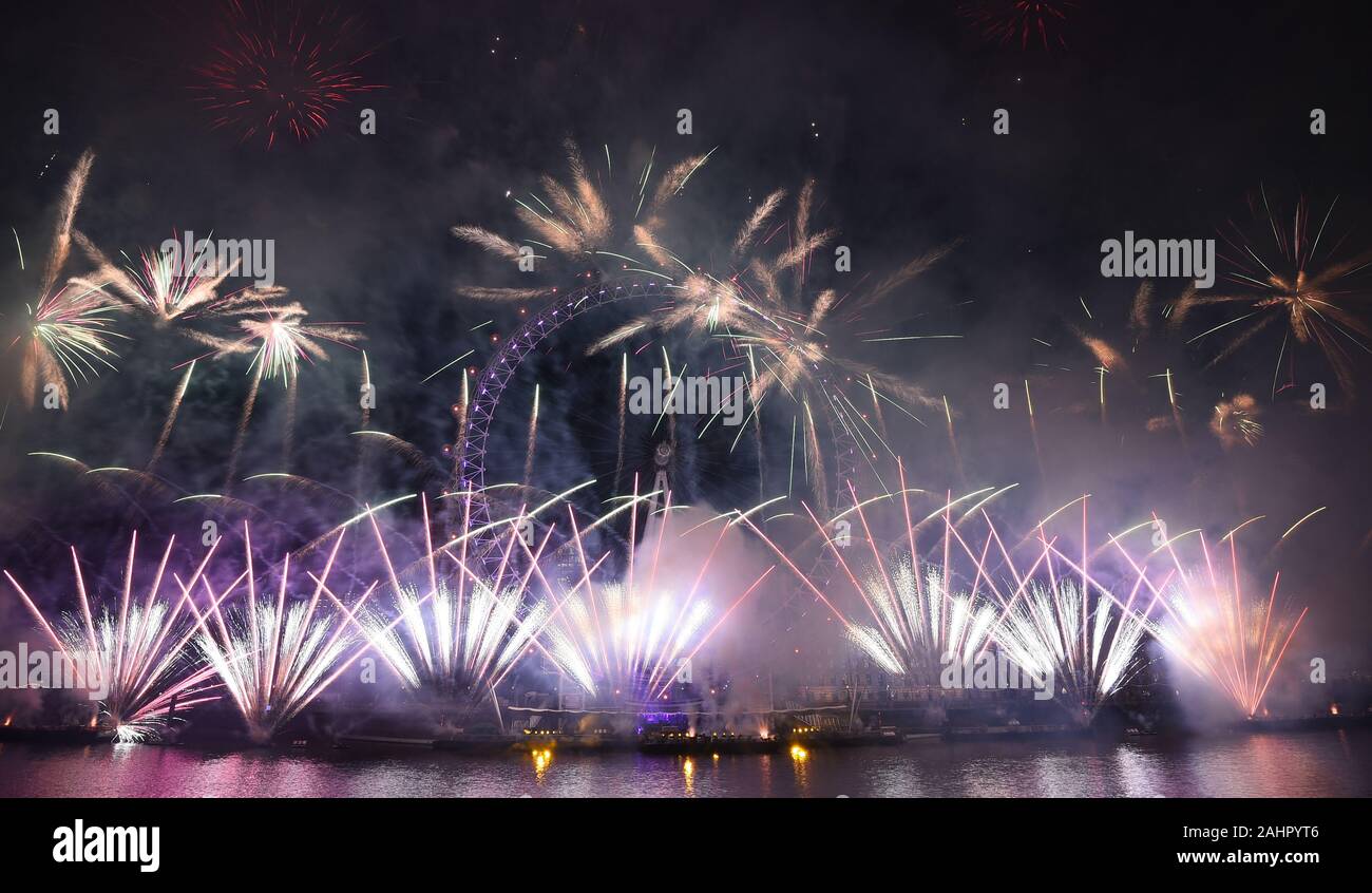 Fireworks light up the sky over the London Eye in central London during the New Year celebrations. Stock Photo