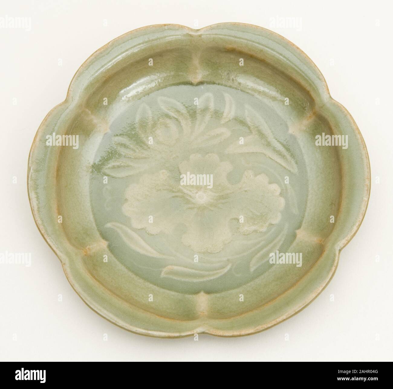 Dish with Petal-Lobed Rim, Lotus, and Waterweeds. 1000–1127. China. Yaozhou ware; stoneware with underglaze molded decoration Stock Photo