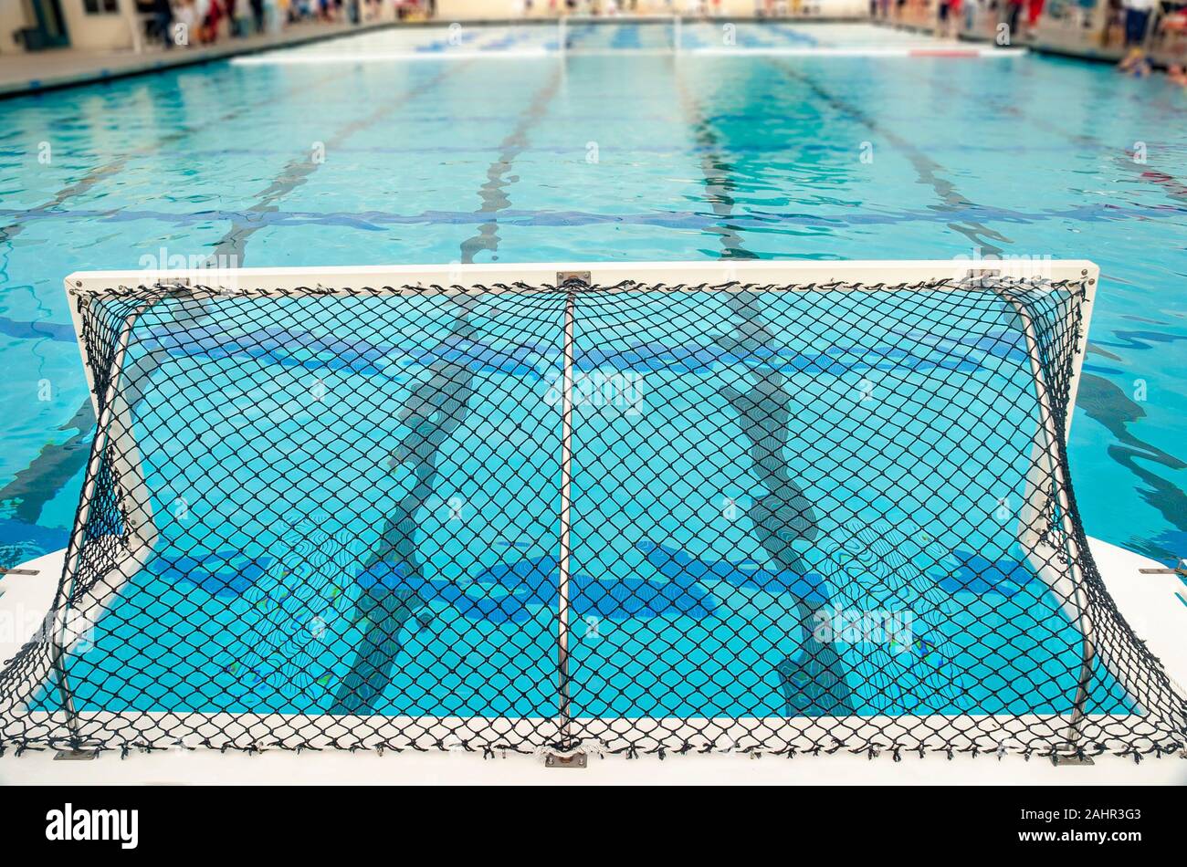 Water Polo goal net shot from behind looking across pool toward opposing goal net. Stock Photo