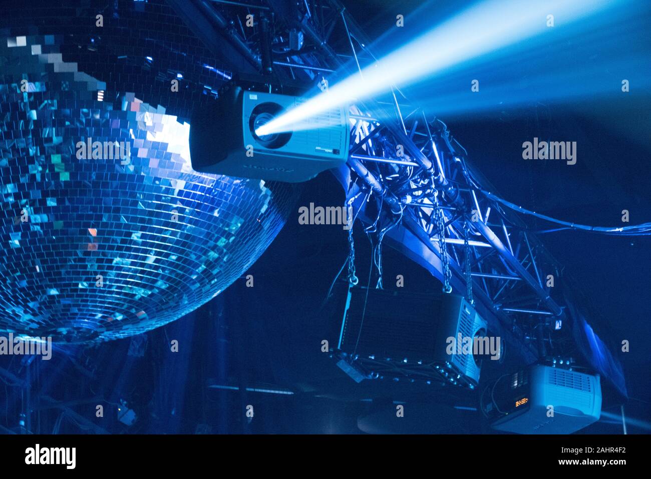 Artistic image of theatrical lighting with large disco ball and shafts of light from single source Stock Photo