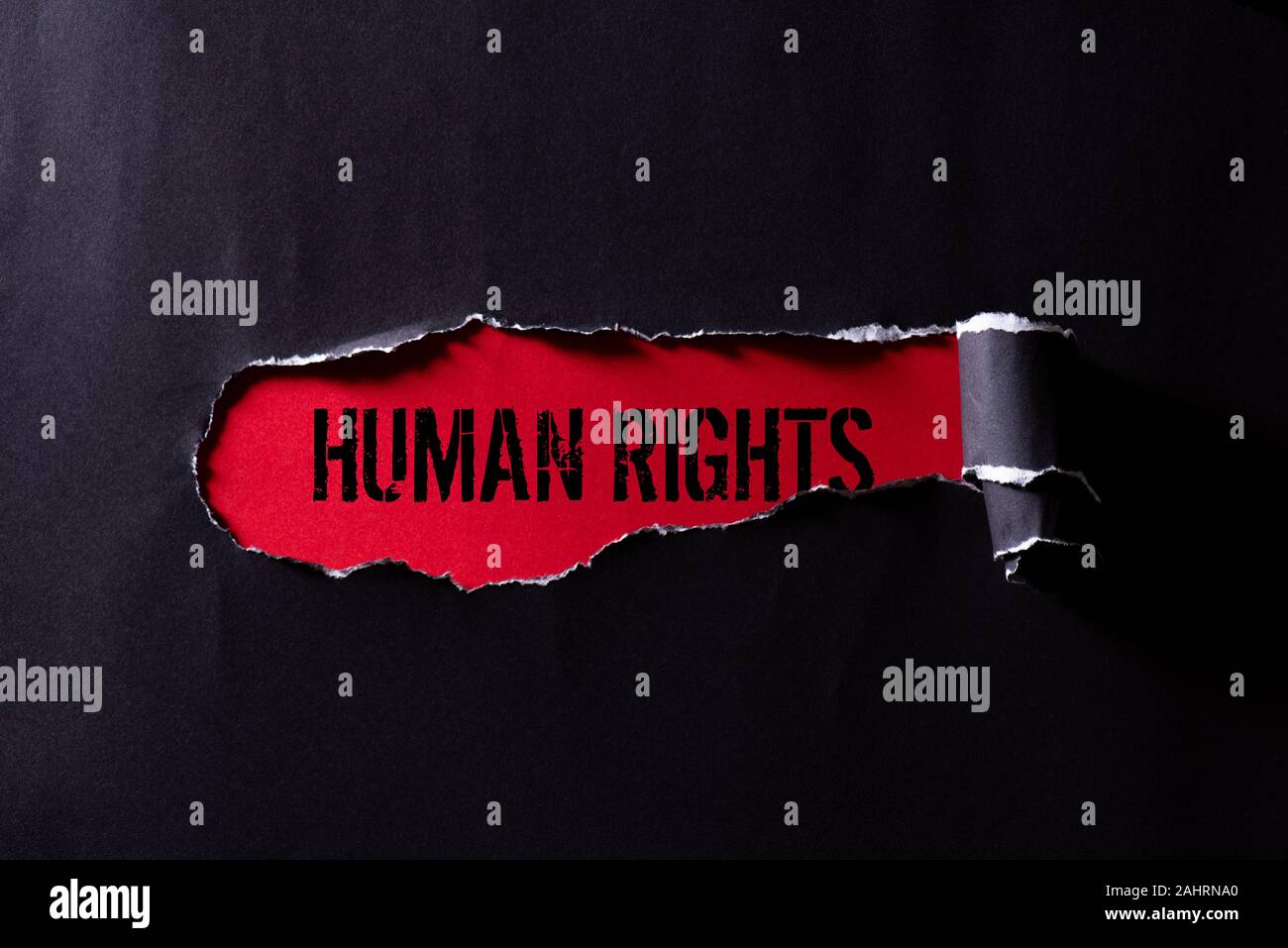 Top view of Black torn paper and the text HUMAN RIGHTS on a red ...