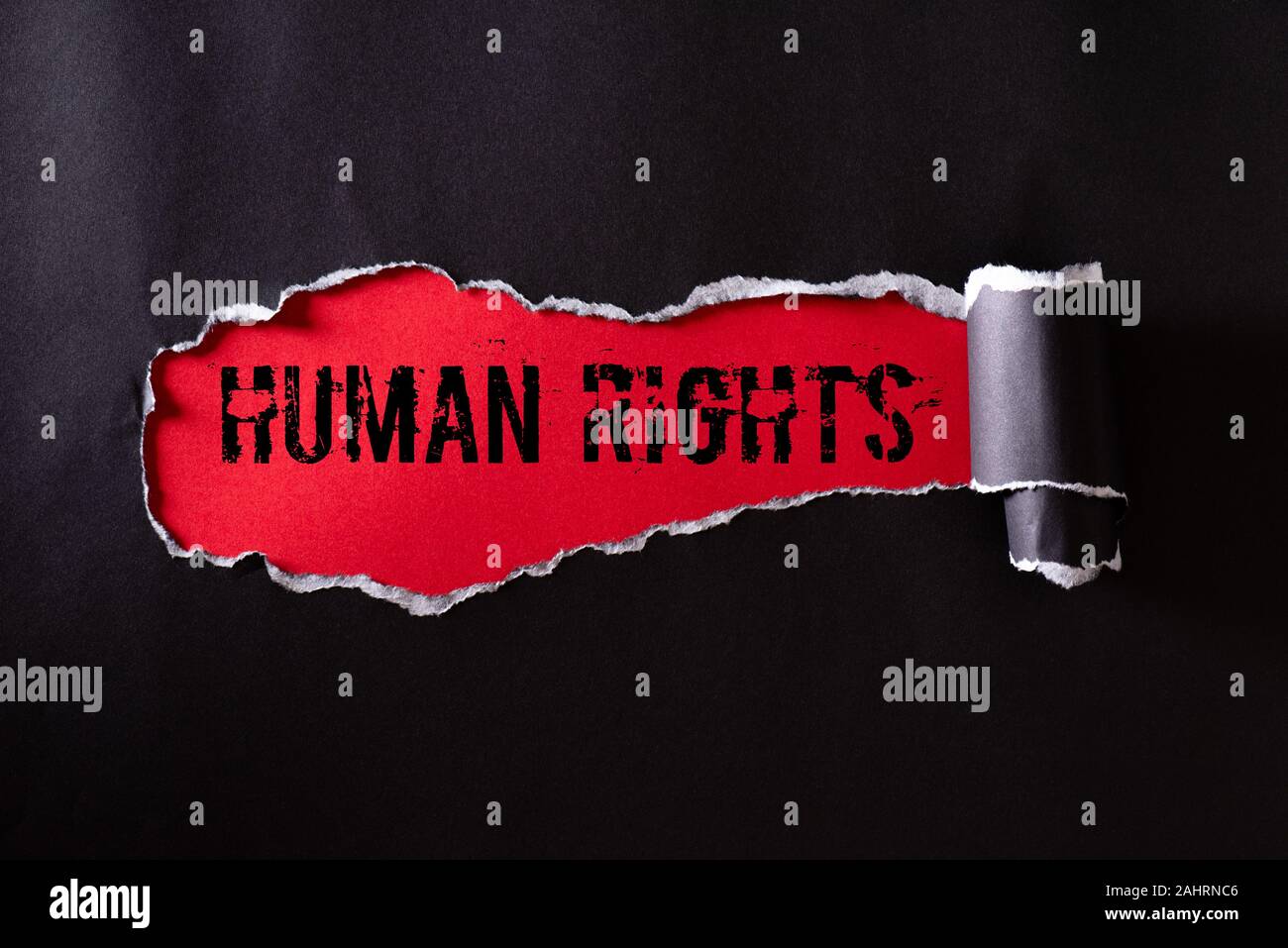 Top view of Black torn paper and the text HUMAN RIGHTS on a red ...
