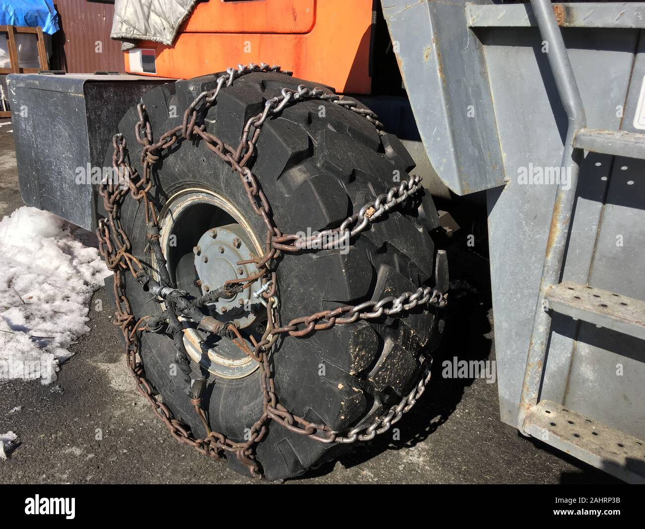 Snow chains put on truck wheel on the ground Stock Photo