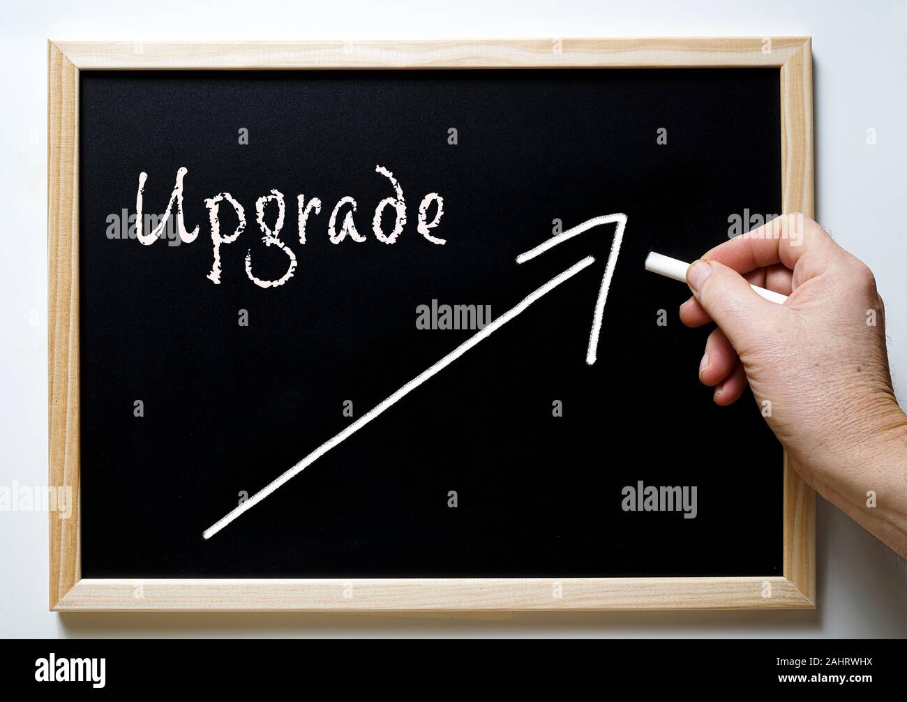 a blackboard with writing upgrade and an arrow indicating the rise Stock Photo