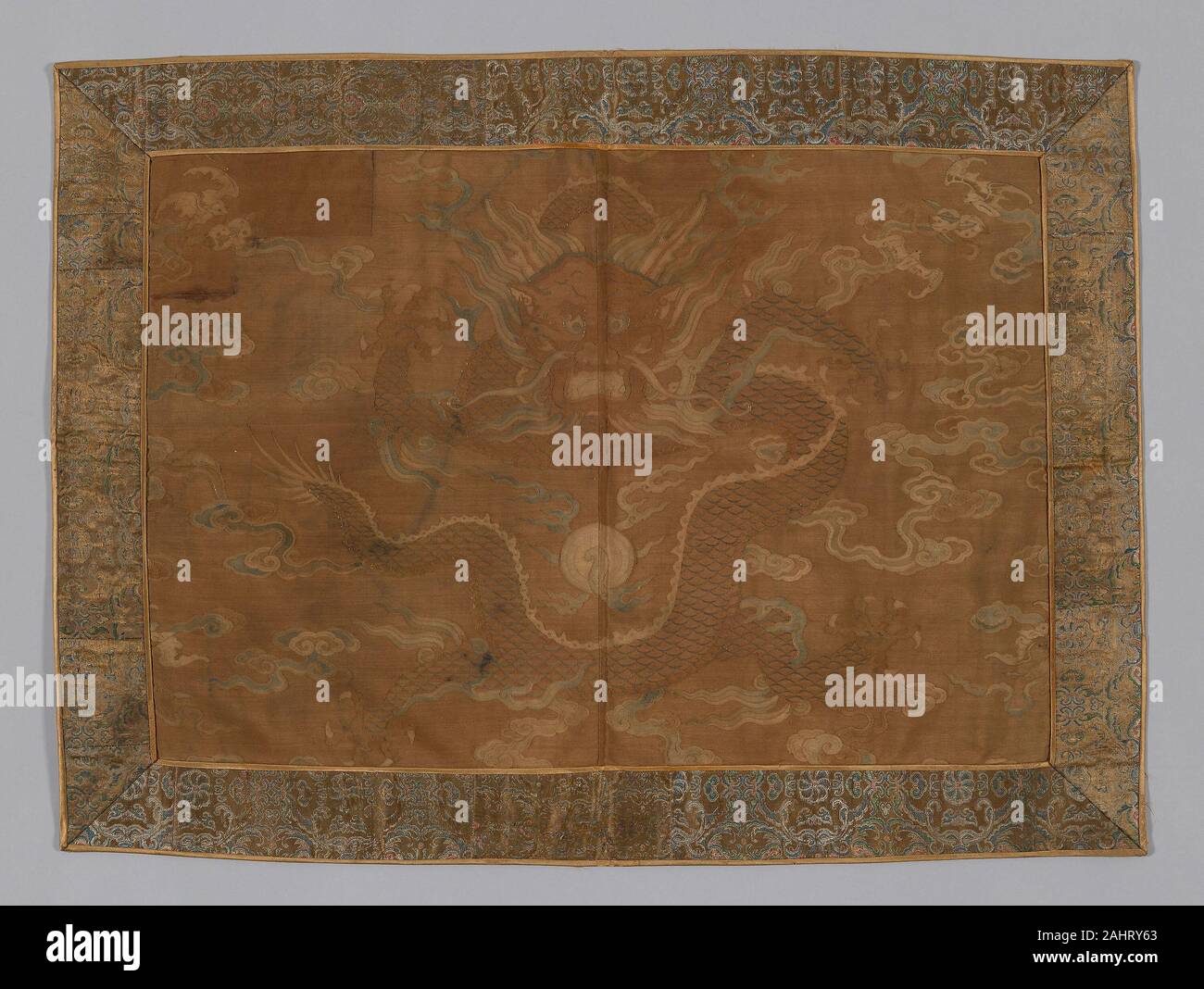 Manchu. Panel (Former Fragment of Man's Coat). 1700–1735. China. Center silk, slit tapestry weave with eccentric and interlaced outlining wefts; painted; border silk, warp-float faced 5 1 satin weave with weft-float faced 1 2 twill interlacings of secondary binding warp-float faced 7 1 satin weave; lined with silk, 3 1 twill damask weave Stock Photo