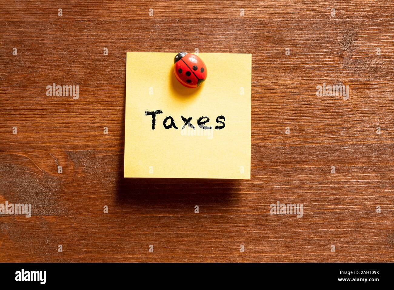 a colored memo sheet with writing  taxes Stock Photo