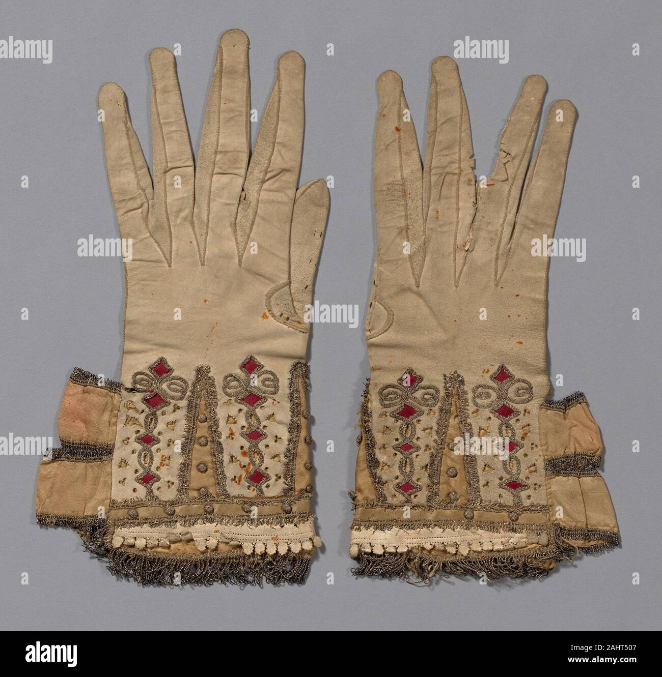 Pair of Gloves. 1601–1650. England. Leather, cut, pricked and slashed; silk satin appliqué; gilt-metal-strip-wrapped silk couching; gilt-metal-strip-wrapped silk woven fringe; balls covered with gilt-metal-wrapped-silk; ribbons of silk, plain weave edged with gilt-metal-strip-wrapped silk woven fringe; lining silk, plain weave; interlining linen, plain weave Stock Photo