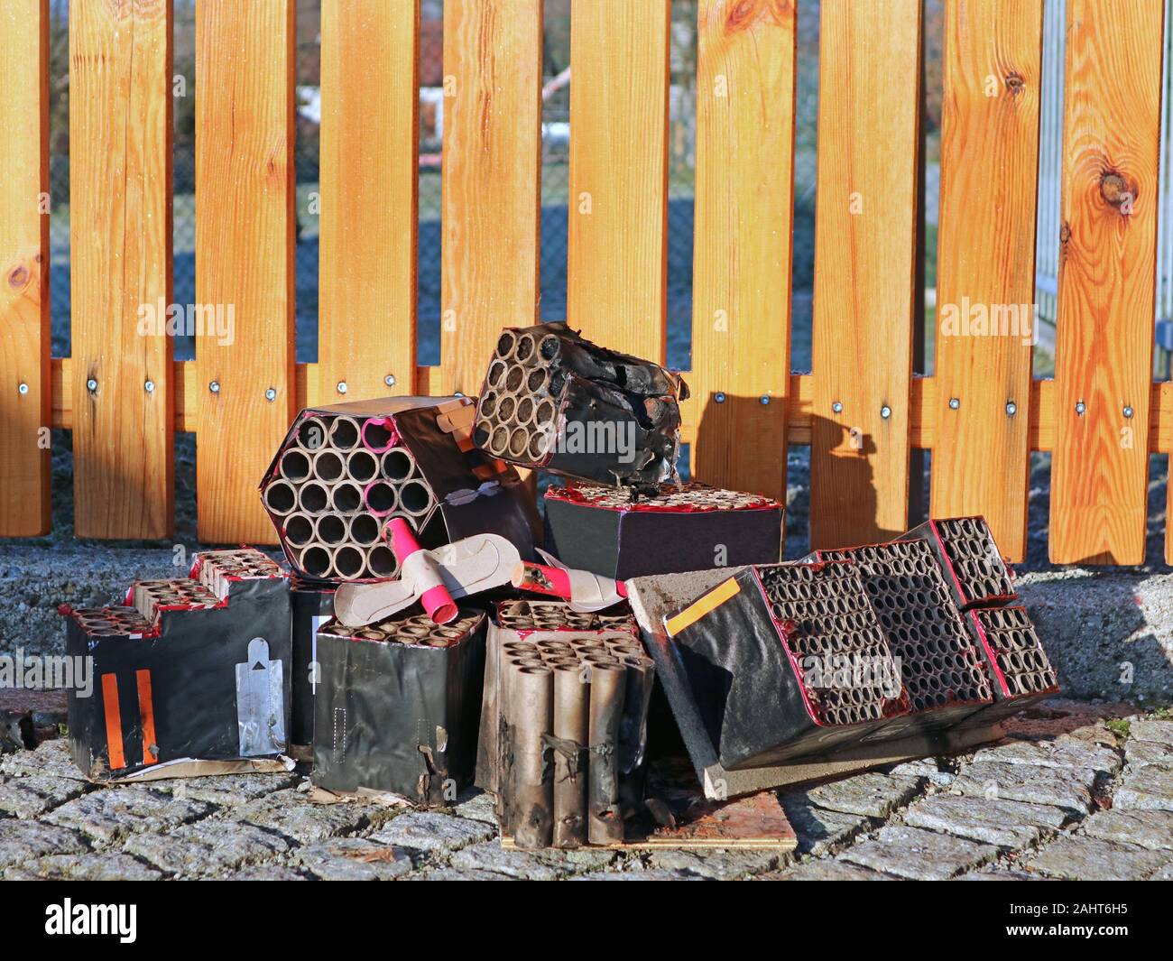 Burned out firework batteries after silvester in front of garden fence with copy space Stock Photo
