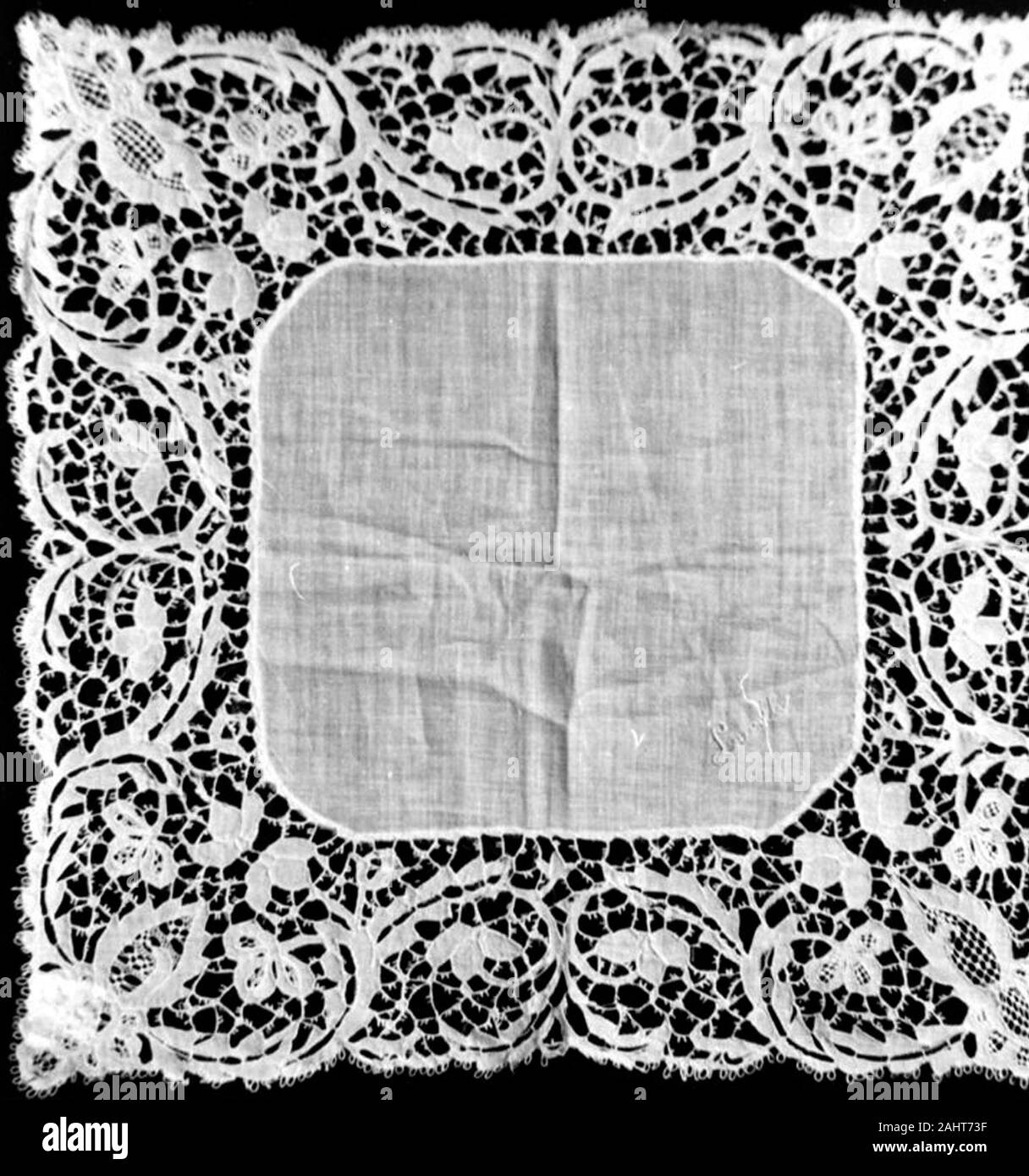 Handkerchief. 1875–1900. Carrickmacross. Cotton and linen, plain weave; embroidered with linen in padded overcast stitches; edged with cotton, plain weave; cut work embroidered with cotton in herringbone; trammed overcast and open buttonhole filling stitches; buttonhole bars decorated with buttonhole picots and darned wheels Stock Photo