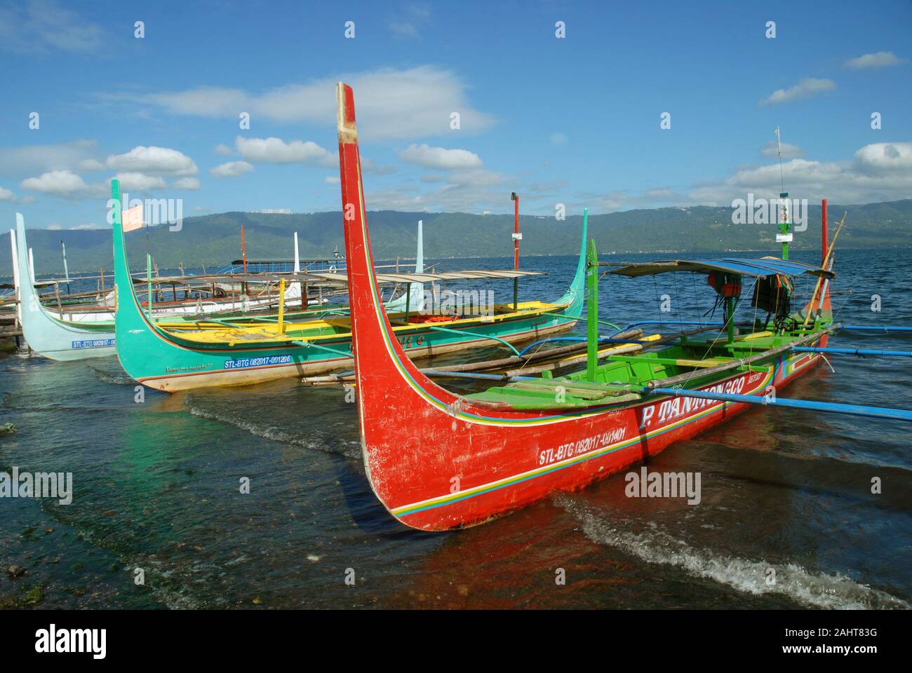 Traditional Bangka boats docked on the shore of Taal Lake on Taal