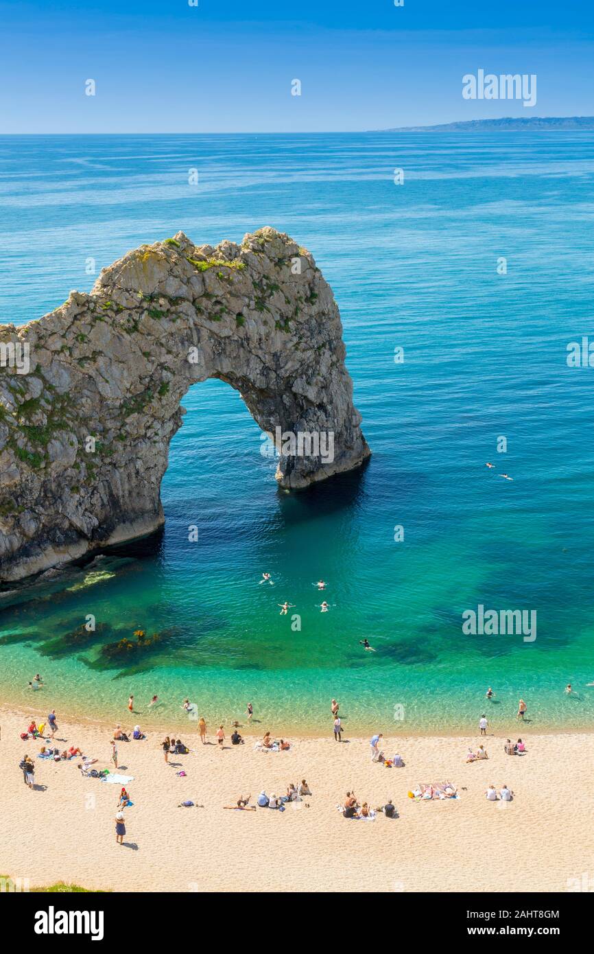The natural limestone arch of Durdle Door is a popular location for summer swimmers on Dorset's Jurassic Heritage Coast, England, UK Stock Photo