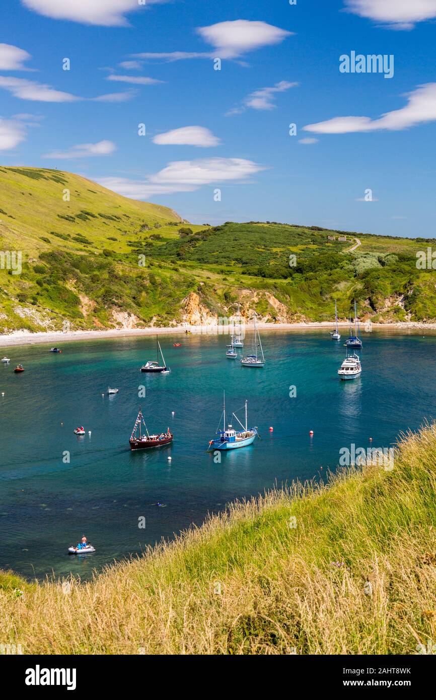 An assortment of various vessels at anchor in Lulworth Cove on Dorset's Jurassic Heritage Coast, England, UK Stock Photo