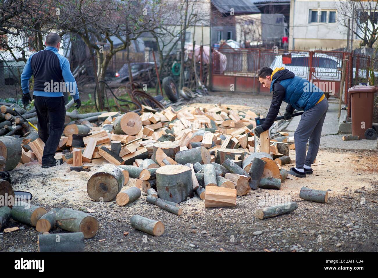 Father and son splitting wood with axes and maul Stock Photo