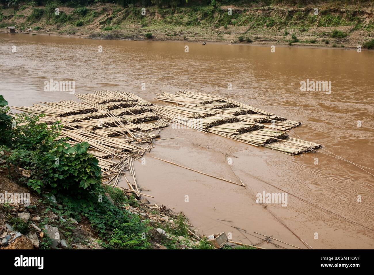 Bamboo trunks are transported over the river to the factory to be processed into chopsticks Stock Photo