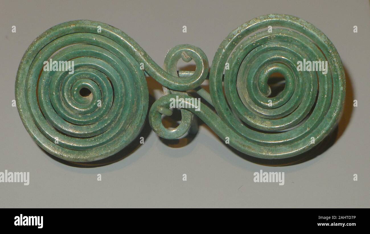 Ancient Greek. Fibula (Garment Pin). 800 BC. Southern Italy. Bronze Worn as a clasp for clothing, this type of double-spiral fibula was popular in Greece before the style was adopted in the southern Italian peninsula. Stock Photo