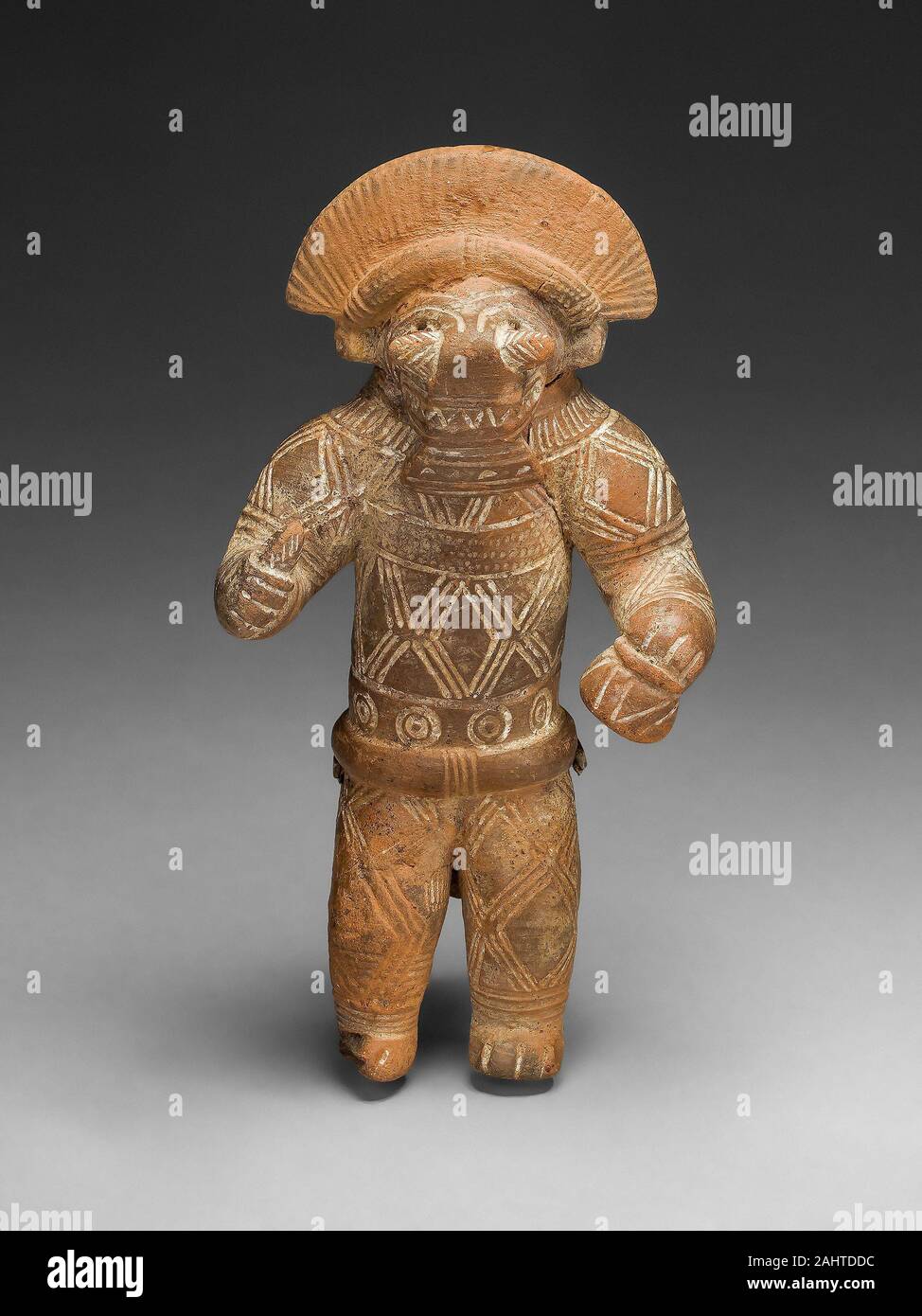 Tairona. Masked Figurine with Boar Headdress, Possibly a Ocarina (Whistle). 1200–1400. Colombia. Ceramic and pigment To this day in Tairona communities, masked individuals dance, personifying the deified forces and phenomena of nature. This act associates the annual round of social and economic activities with the natural world’s cycle of death, fertility, and renewal. Stock Photo