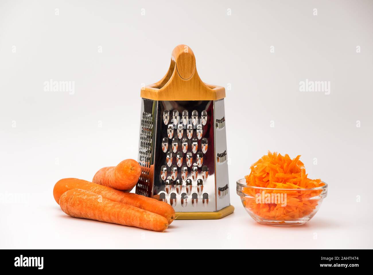 https://c8.alamy.com/comp/2AHTH74/fresh-grated-carrot-in-a-bowl-and-layout-of-carrots-and-grater-isolated-on-white-background-2AHTH74.jpg