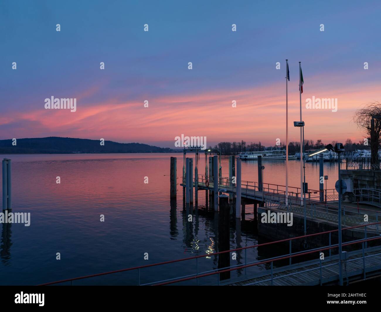 The Pier Where The Ferries Operating On Lake Maggiore Land At Sunset the-pier-where-the-ferries-operating-on-lake-maggiore-land-at-sunset