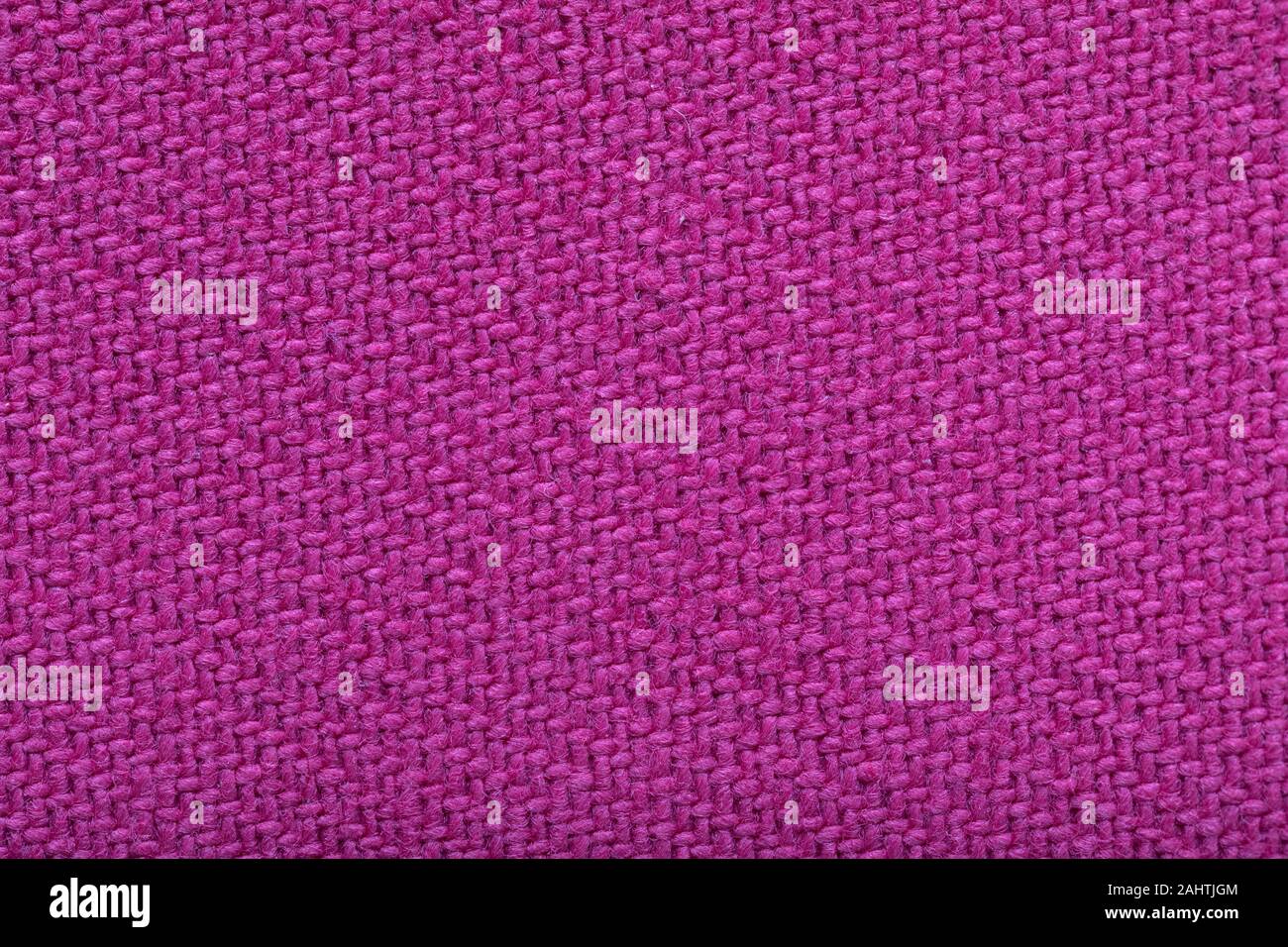twill weaving fabric, pink stitches as a pattern, tissue structure closeup. Stock Photo