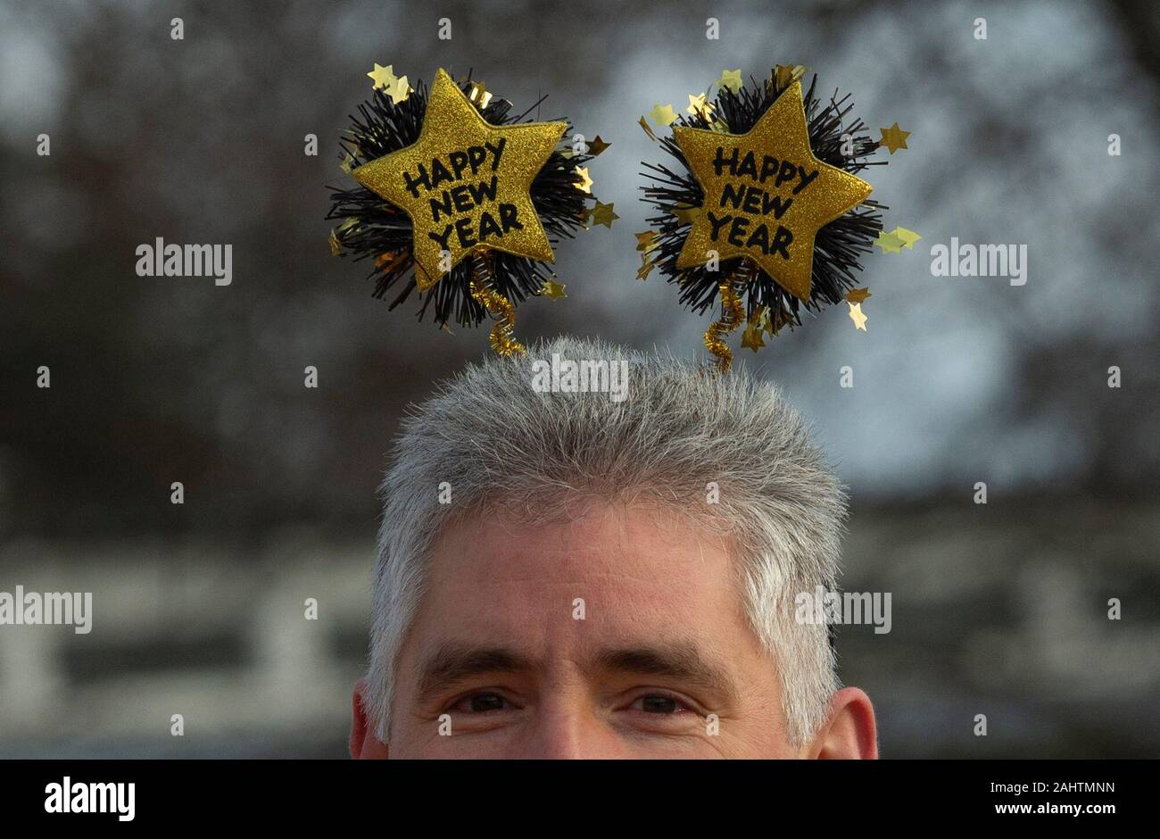 Berlin, Germany. 01st Jan, 2020. A participant in the New Year's bath of the Berlin Seals Association shows his headgear made of a hair band with stars and the inscription 'Happy New Year'. Credit: Paul Zinken/dpa/Alamy Live News Stock Photo