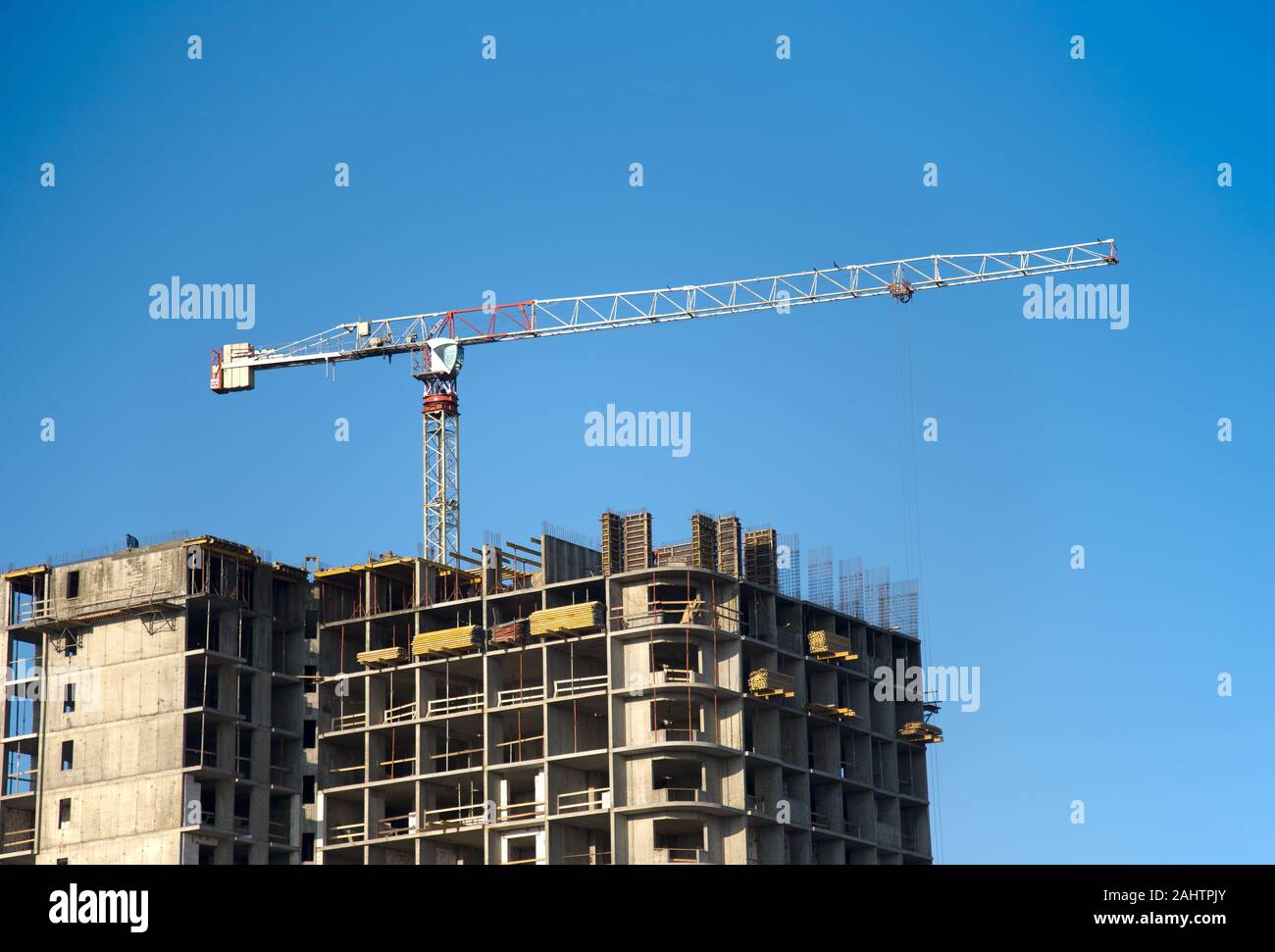 Hydraulic luffing jib tower cranes and workers being poured concrete