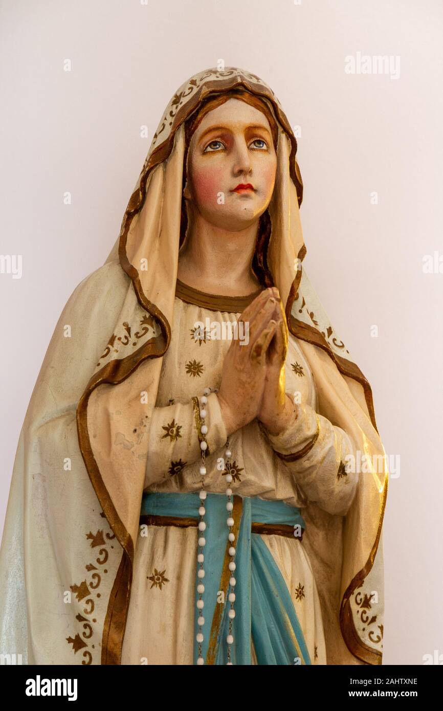Notre Dame de Lourdes (Our Lady of Lourdes) - a statue of the Virgin Mary. Church of the Assumption of the Virgin Mary. Stock Photo