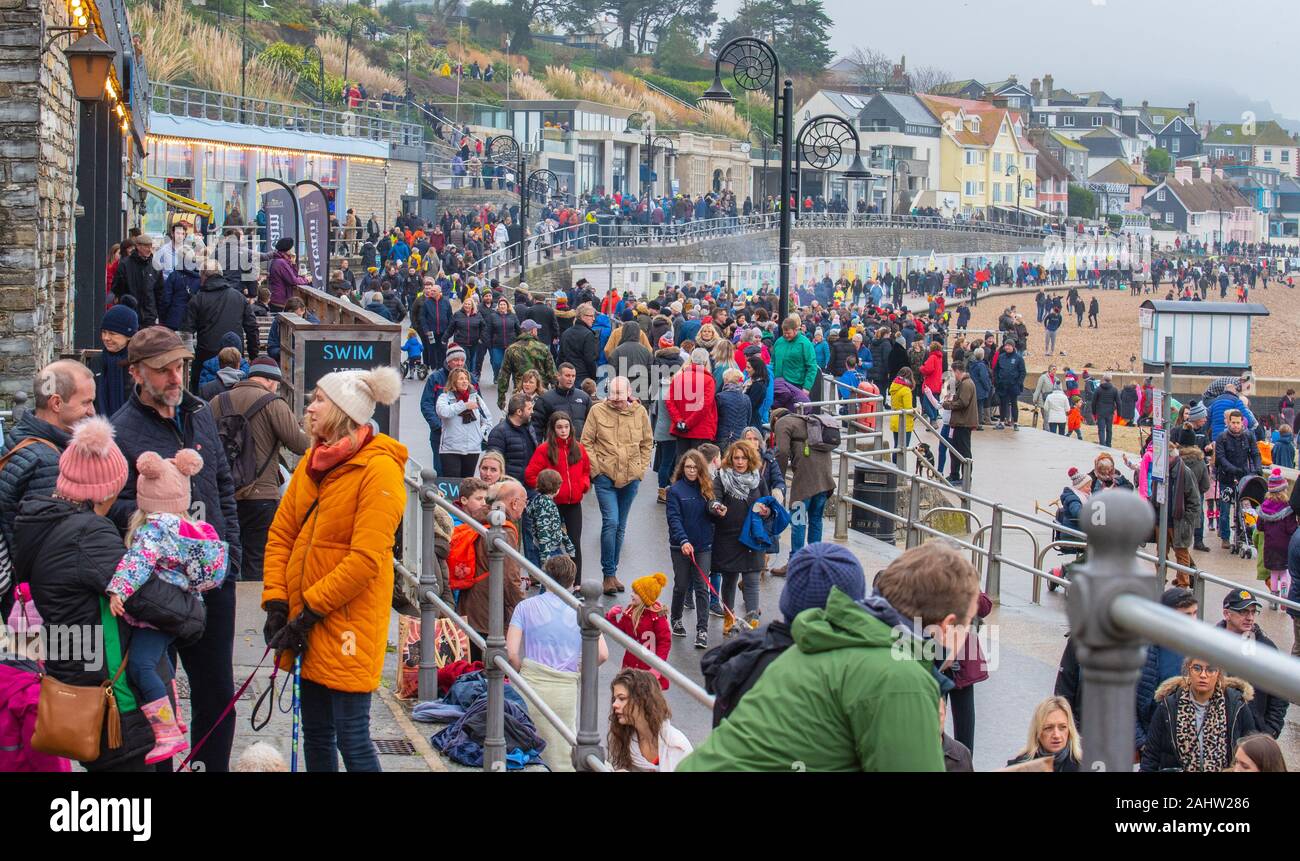 Lyme Regis, Dorset, UK. 1st January 2020. UK Weather: Hundreds plunge into the chilly sea at the  'Lyme Lunge'  New Year swim. The event brought out the crowds on a grey and misty day. Credit: Celia McMahon/Alamy Live News. Stock Photo