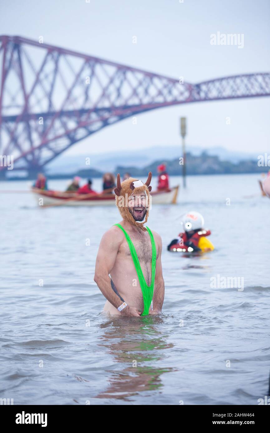 South Queensferry, Edinburgh, Scotland. 1st Jan 2020..  Revellers braving the cold water for the Traditional New Years Day Loony Dook with the Iconic Forth Bridge in the Background Credit: Richard Newton/Alamy Live News Stock Photo