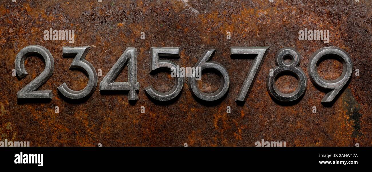 Backgrounds and textures: assorted metal cyrillic digits on a rusty background, typographic art abstract Stock Photo