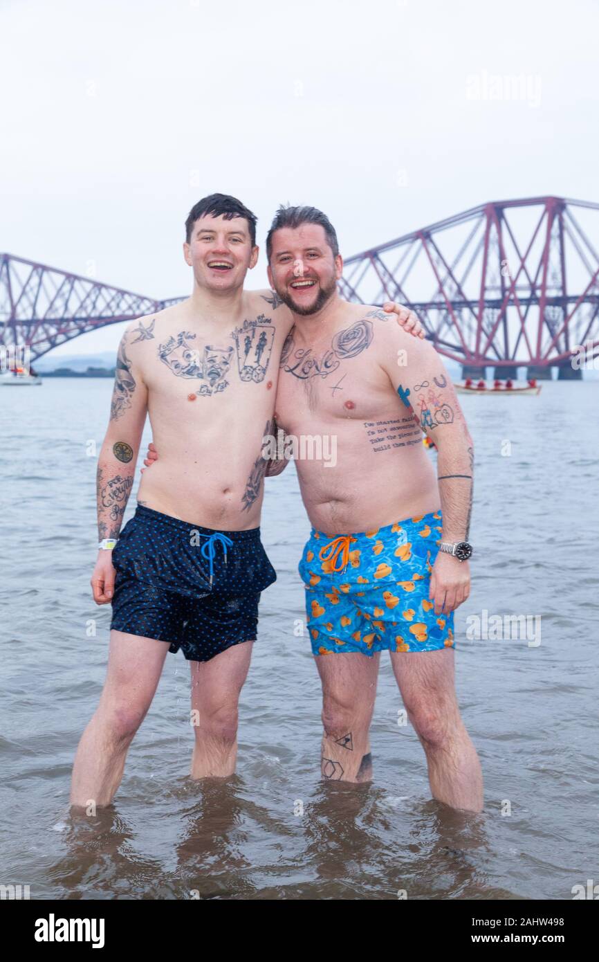 South Queensferry, Edinburgh, Scotland. 1st Jan 2020..  Revellers braving the cold water for the Traditional New Years Day Loony Dook with the Iconic Forth Bridge in the Background Credit: Richard Newton/Alamy Live News Stock Photo