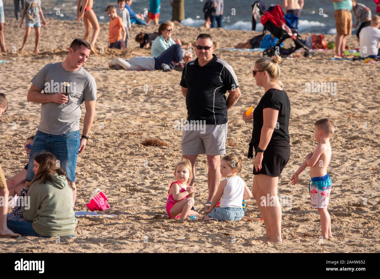 Benidorm, Alicante Province, Spain. 1st January 2020. Tourists and locals enjoy the warm, sunny weather on Levante beach on New Years Day. Family group on the beach. Stock Photo
