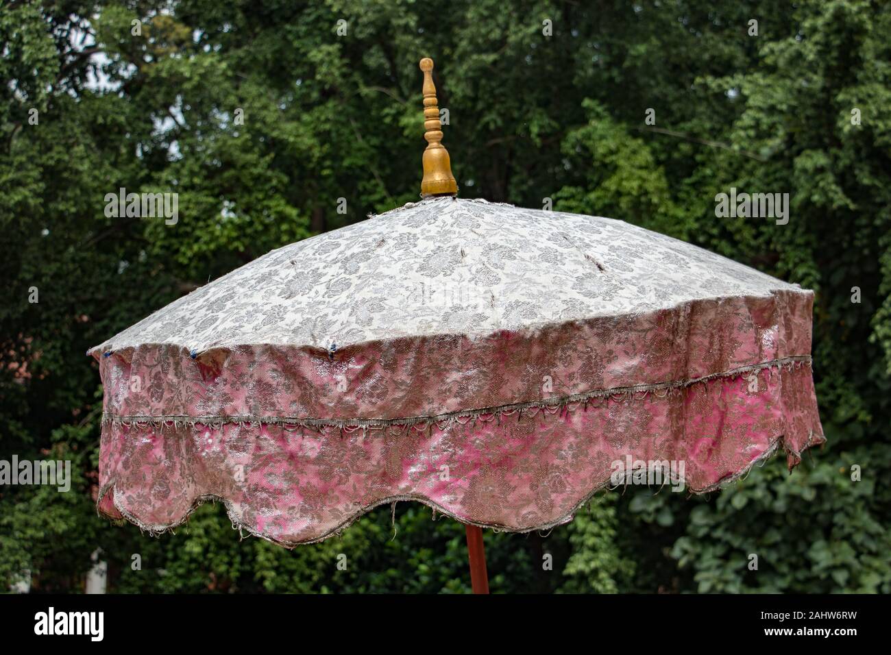 Traditional Buddhist umbrella standing by entry to Buddhist temple