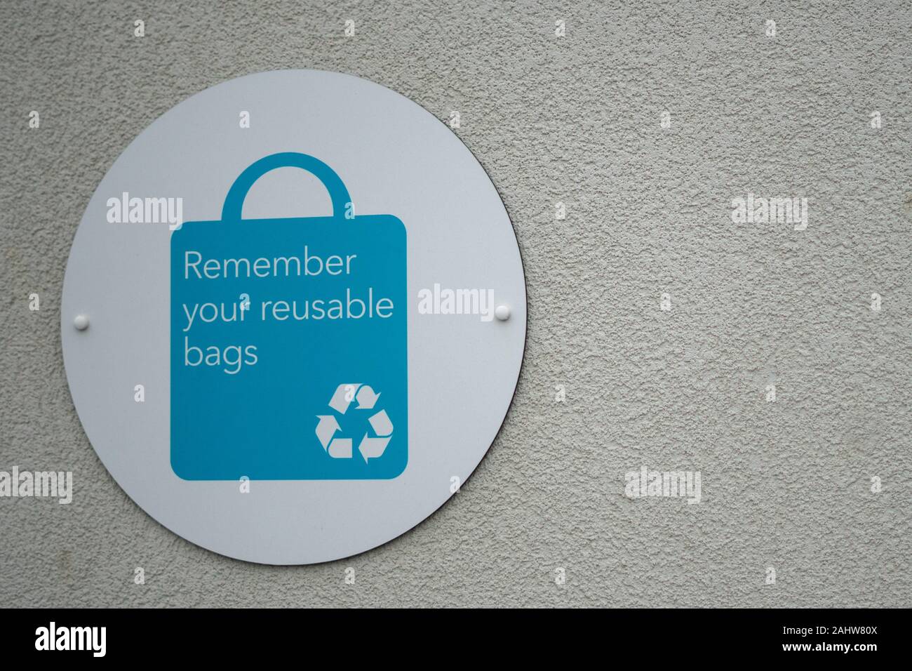 A sign on on the exterior of a supermarket reminding shoppers to use reusable bags Stock Photo
