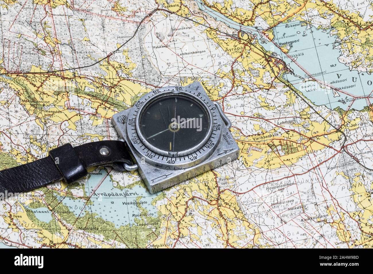 Finnish WW2 era military march compass Suunto, placed on a map of Karelian Isthmus. Stock Photo