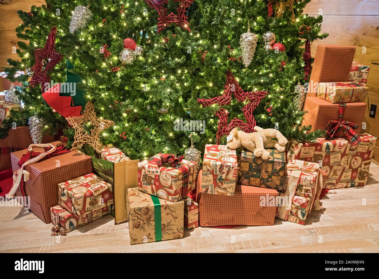 Christmas decorations and gifts under a large Christmas tree. Stock Photo