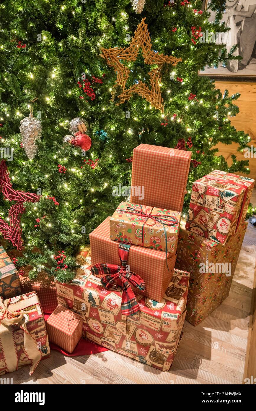 Christmas decorations and gifts under a large Christmas tree. Stock Photo