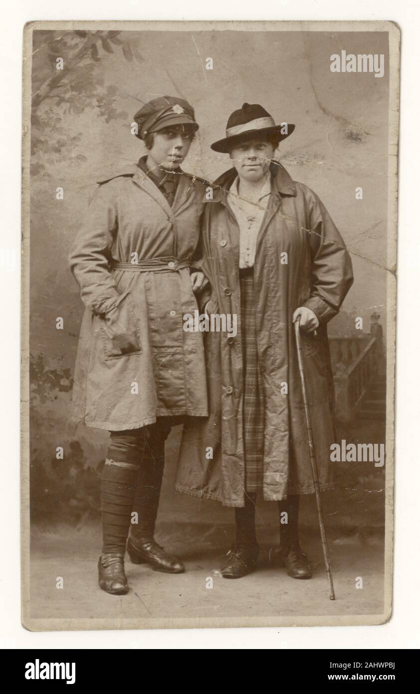 Young woman wearing an Women's Army Auxiliary Corps (WAAC) cap with badge, breeches and cotton wrap-around work coat, shirt and tie, poses for a photo, possibly with her mother, U.K. circa 1917, 1918. Stock Photo