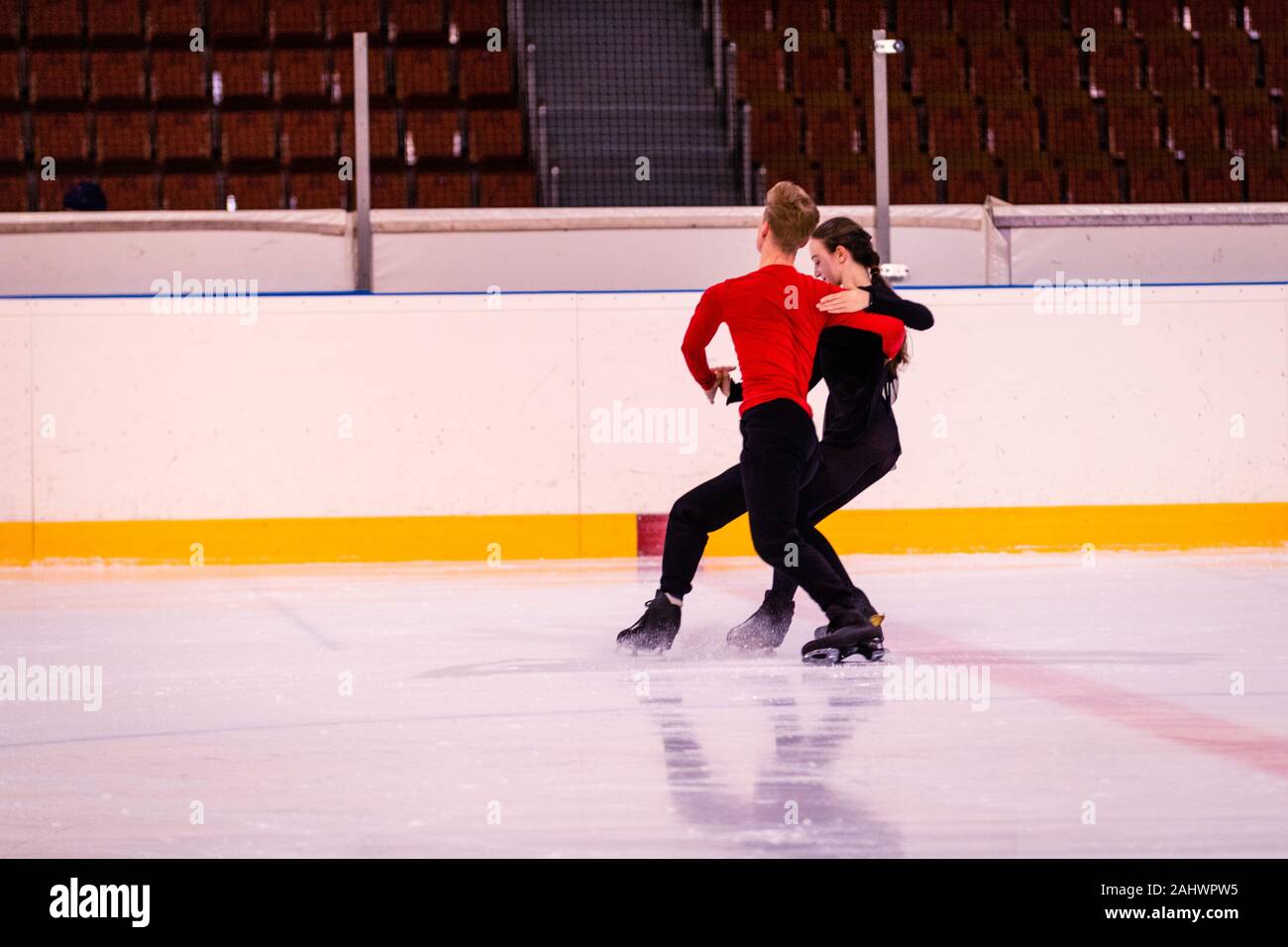 ice arena figure skating training. a pair of young skaters performs
