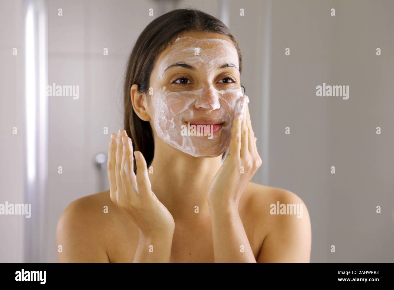 Skincare woman washing face  foaming soap scrubbing skin. Face wash exfoliation scrub soap woman washing scrubbing with skincare cleansing product. En Stock Photo