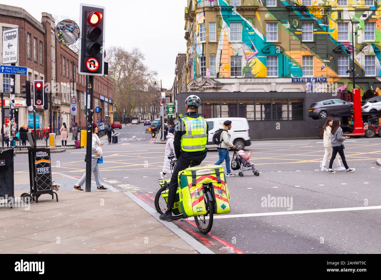 London ambulance paramedic on a bicycle waiting at a traffic light, kings cross, london, uk Stock Photo