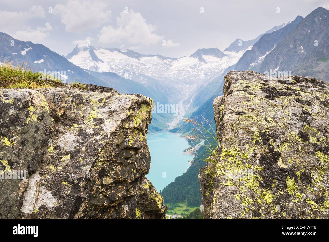 Scenic view from between the rocks of a lake and glacier in the Alps at the border of Austria and Italy Stock Photo