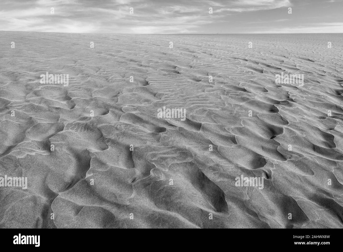 Black and white photo of the sand in the Dunes of Maspalomas, a small desert on Gran Canaria, Spain. Sand and sky. Stock Photo