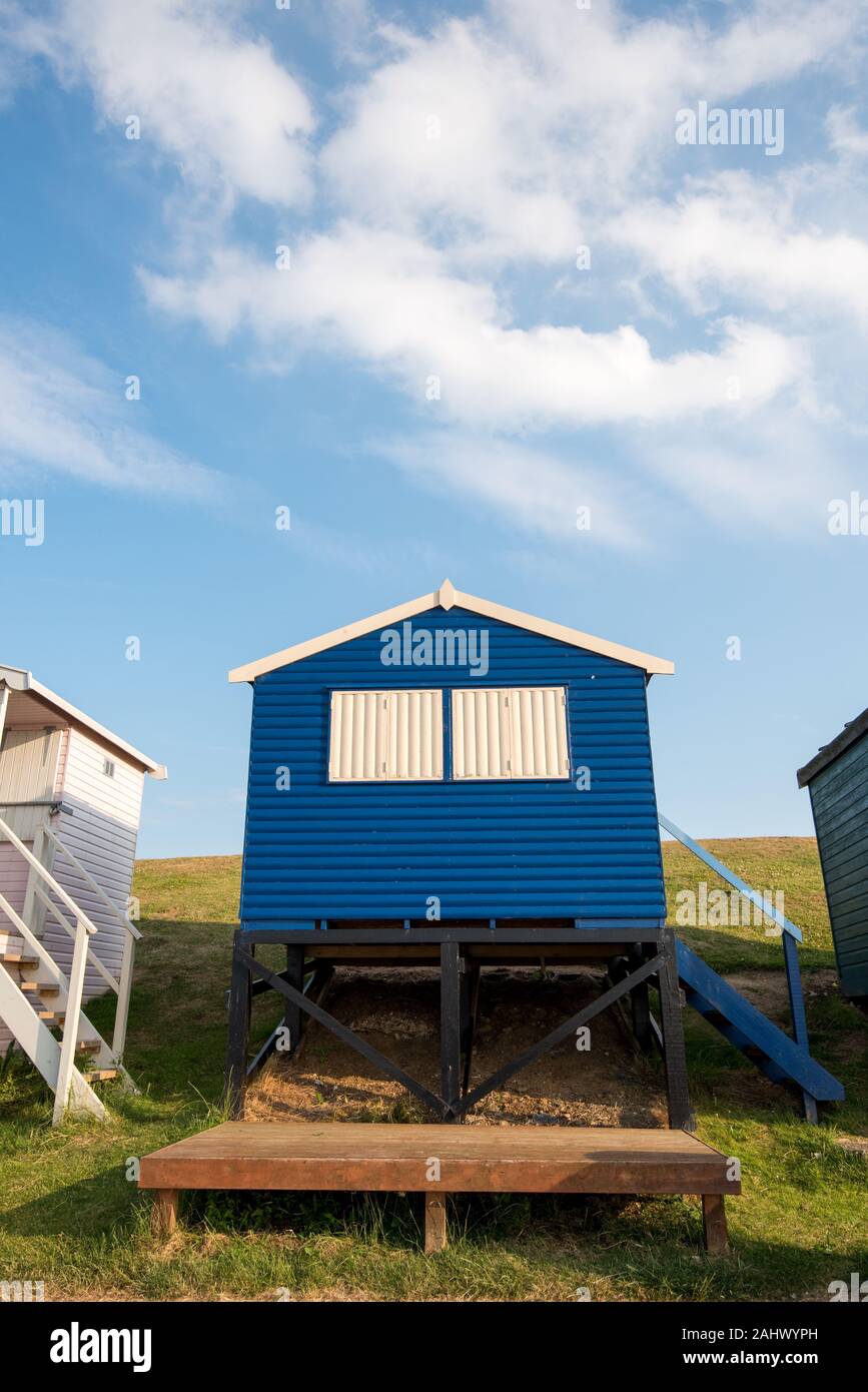Multicoloured holiday wooden beach huts facing the ocean on the beach