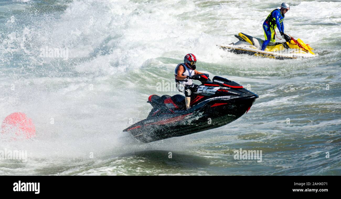 Two jet skiers racing at top speed in the ocean. The jet skier in the  foreground is airborne. Both men are standing up in their jet skis Stock  Photo - Alamy