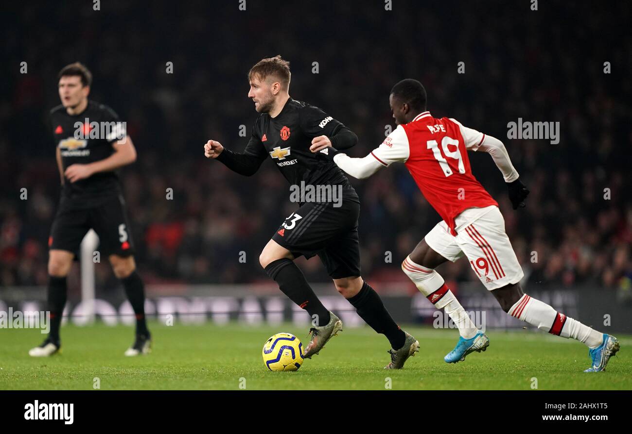 Arsenal's Nicolas Pepe (right) pulls back on Manchester United's Luke Shaw during the Premier League match at the Emirates Stadium, London. Stock Photo